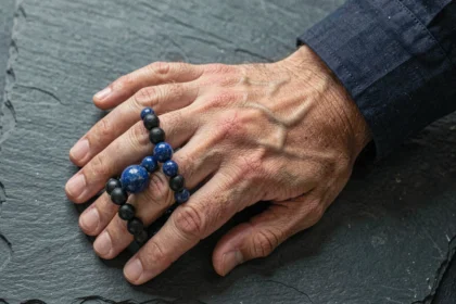 Bracelet en pierre naturelle onyx et lapis-lazuli pour homme posé sur une ardoise sombre
