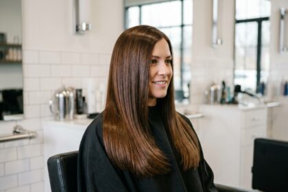 Femme aux cheveux châtains brillants après un traitement gloss dans un salon de coiffure moderne