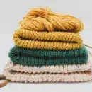 a stack of knitted sweaters and a pair of scissors